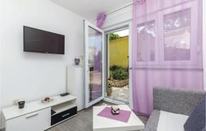 a living room with a tv and a purple curtain at 2 Bedroom Cozy Apartment In Smrika in Šmrika