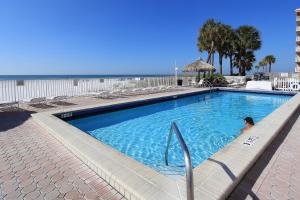 a person sitting in a swimming pool next to the beach at Sea Breeze 608 in St Pete Beach