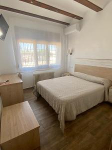 מיטה או מיטות בחדר ב-HOSTAL RESTAURANTE SAN ISIDRO