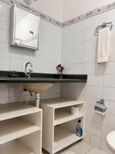 een badkamer met een wastafel en een spiegel bij Delphin Apartamento 8 in Ilhabela