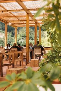 un grupo de personas sentadas en mesas en un restaurante en Selina Gerês, en Gerês