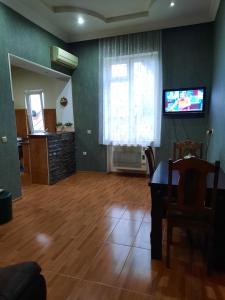 a living room with a table and a television on a wall at Sisi Guest House in Kutaisi