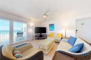a living room with two couches and a flat screen tv at Holiday Villas III 201 in Clearwater Beach