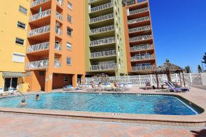 a swimming pool in front of a apartment complex at Holiday Villas III 201 in Clearwater Beach