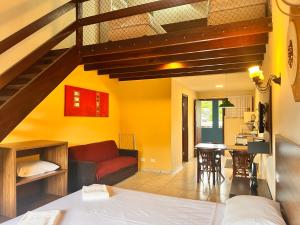 a bedroom with a staircase and a living room at Delphin Apartamento 7 in Ilhabela