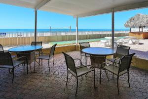 patio ze stołami i krzesłami oraz plażą w obiekcie Holiday Villas III 505 w mieście Clearwater Beach