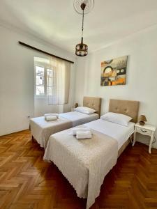 two beds in a room with wooden floors at Old Town Heart in Kotor