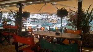 
a dining area with tables, chairs and umbrellas at Loutro Holidays in Loutro
