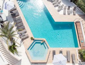 an overhead view of a swimming pool with chaise lounge chairs at Le Confidentiel Hôtel & SPA in Saint-Raphaël