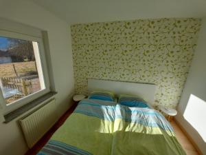 a small bedroom with a bed and a window at APARTMA GONZO in Bovec