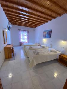 ein Schlafzimmer mit drei Betten und einer Holzdecke in der Unterkunft Anemos Hotel & Apartments in Ornos + 91 Fotos