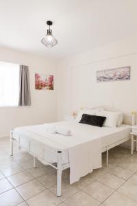 a white bedroom with a large white bed at Alexandros Luxury Apartments Nydri in Nydri