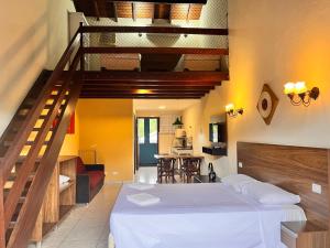 a bedroom with a bed and a spiral staircase at Delphin Apartamento 7 in Ilhabela