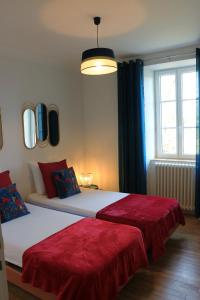 1 dormitorio con 2 camas con sábanas rojas y ventana en Le gîte de la glycine, en Palmas