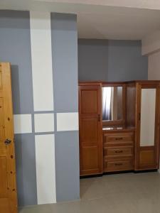 Zimmer mit einer Wand und einem Holzschrank in der Unterkunft Skyland Oasis in Carnbee Village