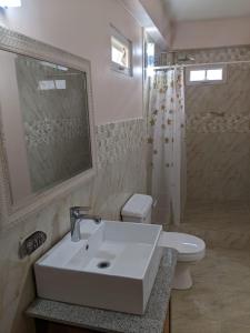 Baño blanco con lavabo y aseo en Skyland Oasis en Carnbee Village