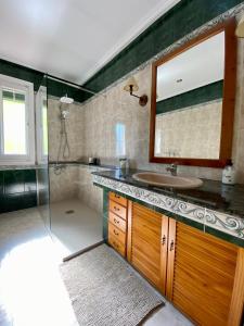 a bathroom with a sink and a shower with a mirror at Apartamento Rural El Balcón in Alhama de Aragón
