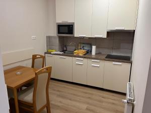 a small kitchen with a table and a microwave at Brookforest Apartman in Hajdúszoboszló