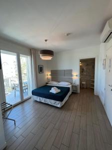 Hotel Riva e Mare في ريميني: غرفة نوم بسرير وارضية خشبية