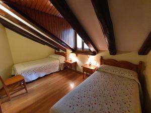 a bedroom with two beds and a large window at Casa Duplex La Buhardilla in Torla-Ordesa