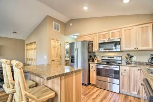 eine Küche mit Holzschränken und einem Kühlschrank aus Edelstahl in der Unterkunft Breezy Point Cabin with Fire Pit - Walk to Lake in Breezy Point