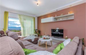a living room with a couch and a tv at Cozy Home In Smrika With House Sea View in Šmrika