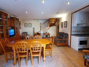 cocina y comedor con mesa de madera y sillas en Casa Duplex La Buhardilla, en Torla