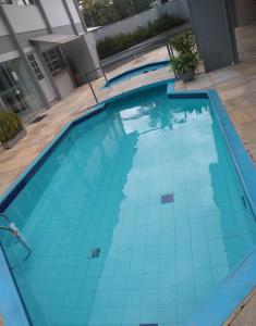 a swimming pool with turquoise tiles on the floor at Caravaggio Praia Hotel in Florianópolis
