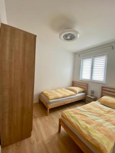 a bedroom with two beds and a window at Apartman M & M, Schöne Wohnung nur 200m vom Strand in Zaton