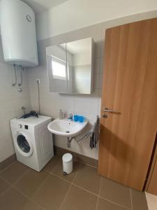 a bathroom with a washing machine and a sink at Apartman M & M, Schöne Wohnung nur 200m vom Strand in Zaton