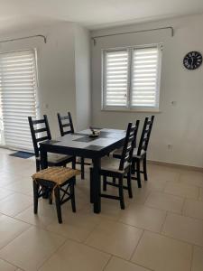 a dining room with a black table and chairs at Apartman M & M, Schöne Wohnung nur 200m vom Strand in Zaton