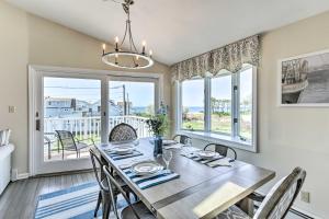 a dining room with a table and chairs and windows at Westbrook Home with Ocean Views - Walk to Beach in Westbrook