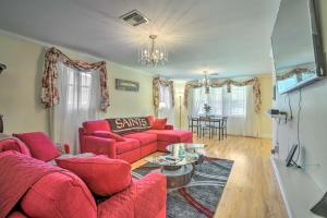 uma sala de estar com sofás vermelhos e uma mesa em New Orleans Getaway - 5 Mi to French Quarter! em Nova Orleães