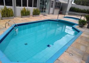 a swimming pool with blue water at Caravaggio Praia Hotel in Florianópolis