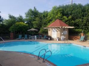a large blue swimming pool with a gazebo at Ramada by Wyndham Gainesville in Gainesville