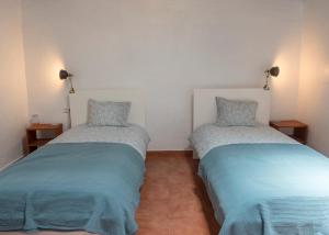 two beds in a room with blue and gray sheets at Vista Del Drago in Icod de los Vinos