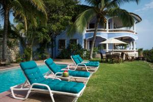 un grupo de sillones azules junto a una piscina en Villa del Puerto, en Puerto Escondido