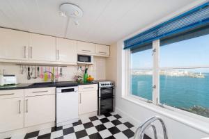 Una cocina con gabinetes blancos y una ventana grande. en The Lighthouse, en St Ives