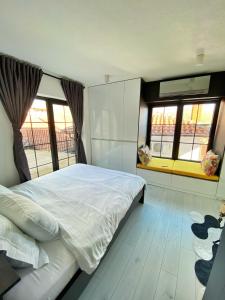 a bedroom with a white bed and windows at Wild Pear Old Town boutique accommodation in Ohrid +20 photos