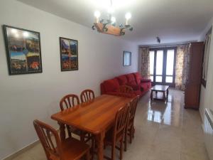 een eetkamer met een tafel en een rode bank bij Apartamento Casa Go in Torla