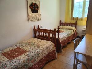 a bedroom with two beds and a table at Apartamento Maladeta in Torla-Ordesa