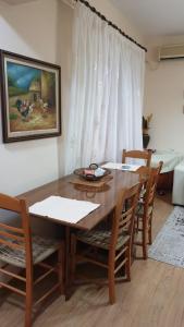 uma sala de jantar com uma mesa de madeira e cadeiras em Valentina's Apartment em Tirana