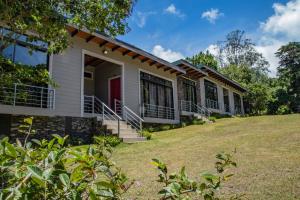 a house with a lawn in front of it at YerbaBuena Lodge in Monteverde Costa Rica +30 photos