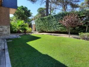 einen Hof mit grünem Gras und einem Backsteingebäude in der Unterkunft patricia in Villaviciosa de Odón