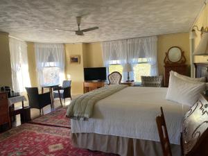 1 dormitorio con 1 cama, mesa y sillas en Moseley Cottage Inn and The Town Motel en Bar Harbor