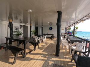 a restaurant with tables and white chairs and the ocean at Gafitas in Playa Blanca