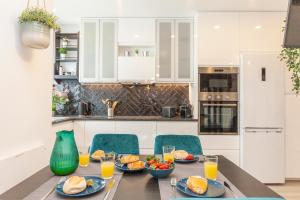 una cocina con una mesa con productos para el desayuno y zumo de naranja en Andorinha City Heart Apartment in Lagos, en Lagos 18 fotos más