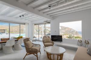 een woonkamer met witte meubels en grote ramen bij Villa Leda Mykonos in Mykonos-stad