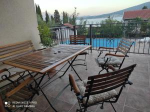 a patio with a wooden table and chairs and a pool at Mio Lux in Baošići