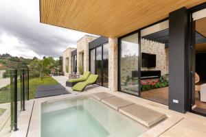 an indoor swimming pool in the backyard of a house at Villa al lado de la represa de Guatapé con jacuzzi y cancha de tennis privada in El Peñol
